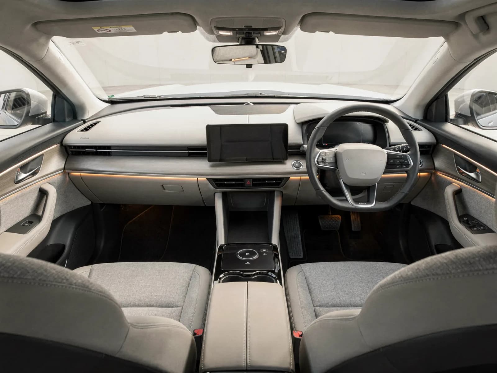 Minimal electric-crossover interior with a wide centre display, open console and light upholstery