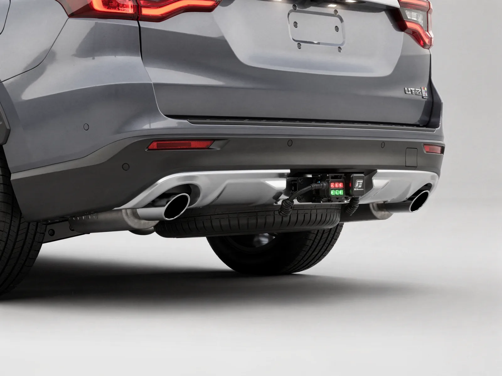 Rear three-quarter view of a full-size SUV showing the integrated hitch receiver and trailer wiring block