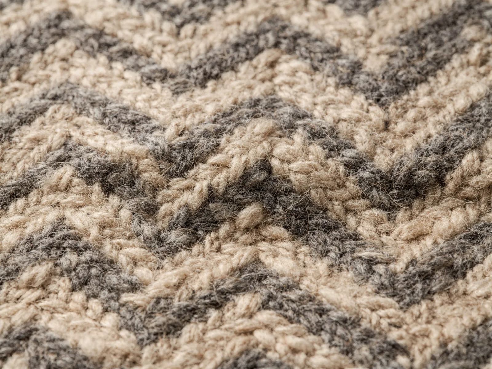 Macro shot of a two-tone herringbone wool weave showing individual lambswool and cotton yarns
